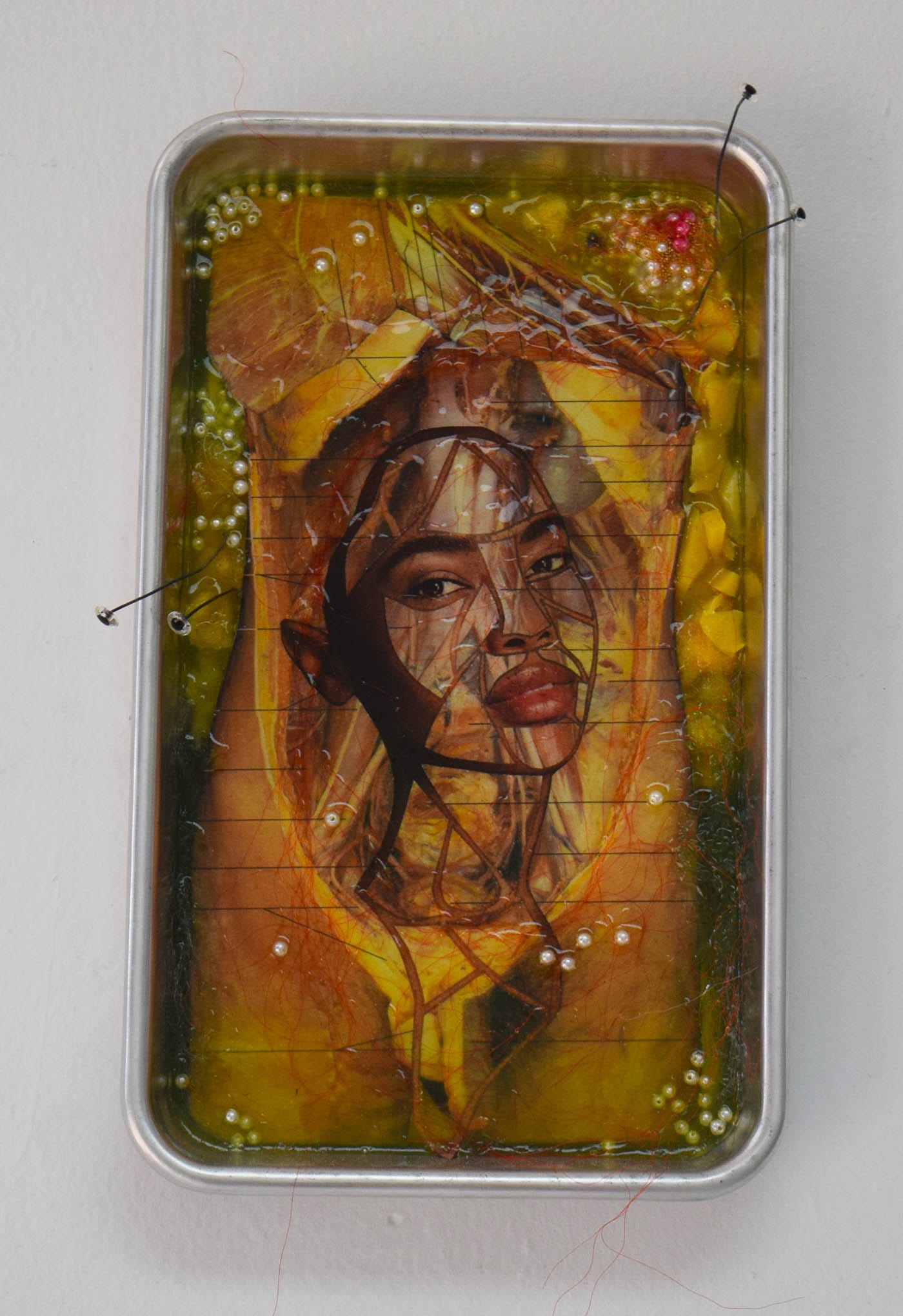 Doreen Garner, "Golden Child" (2016), silicone, dissected anatomy book, dissected black women's magazine, teddy bear eyes, wire, dissection tray, rubber, 9 x 5 in