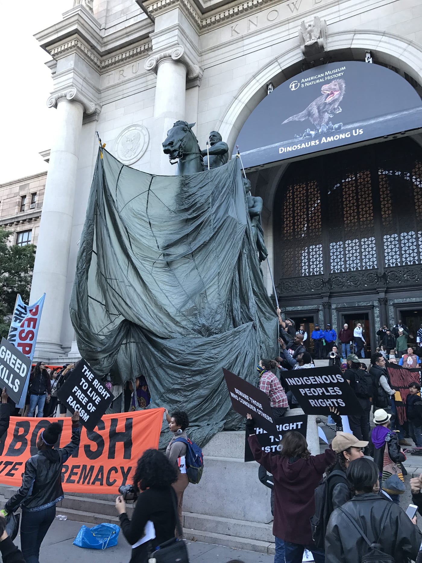 Protesters covering the Roosevelt statue with a parachute