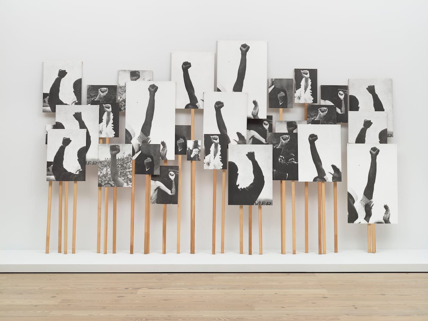 Annette Lemieux, "Left Right Left Right" (1995), 30 photolithographs and 30 pine poles, dimensions variable (Whitney Museum of American Art, New York; purchase, with funds from the Print Committee; courtesy the Whitney Museum of American Art)