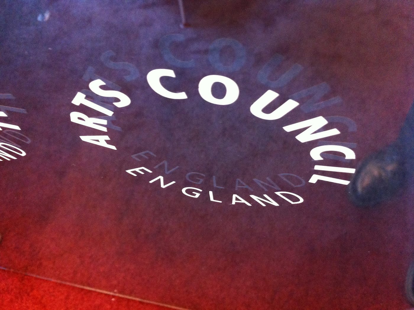 The Arts Council England logo on the door to an institution it supports (photo by Howard Lake/Flickr)