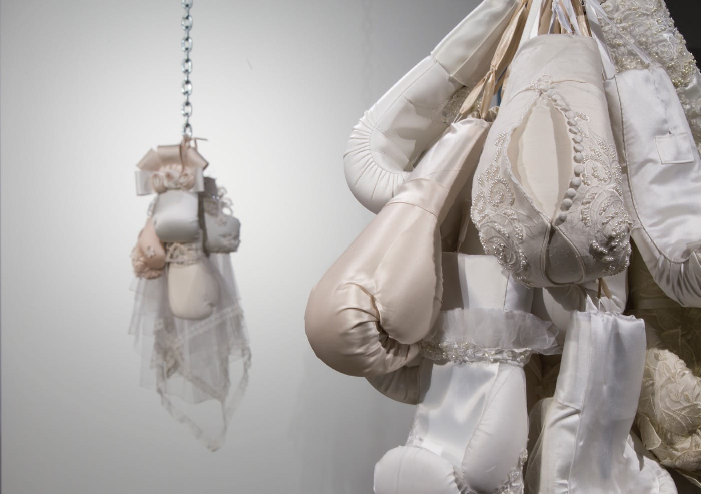 Installation view of Zoe Buckman's <em>Imprison Her Soft Hand</em> with "She dwells with beauty" (2016, right), chain, gloves, wedding dress, 36 x 24 x 19 in, and "Ode On" (2016, left) wedding dress, boxing gloves, chain, 41 x 16 x 17 in (all images by Anthony Alvarez and courtesy Project for empty Space)