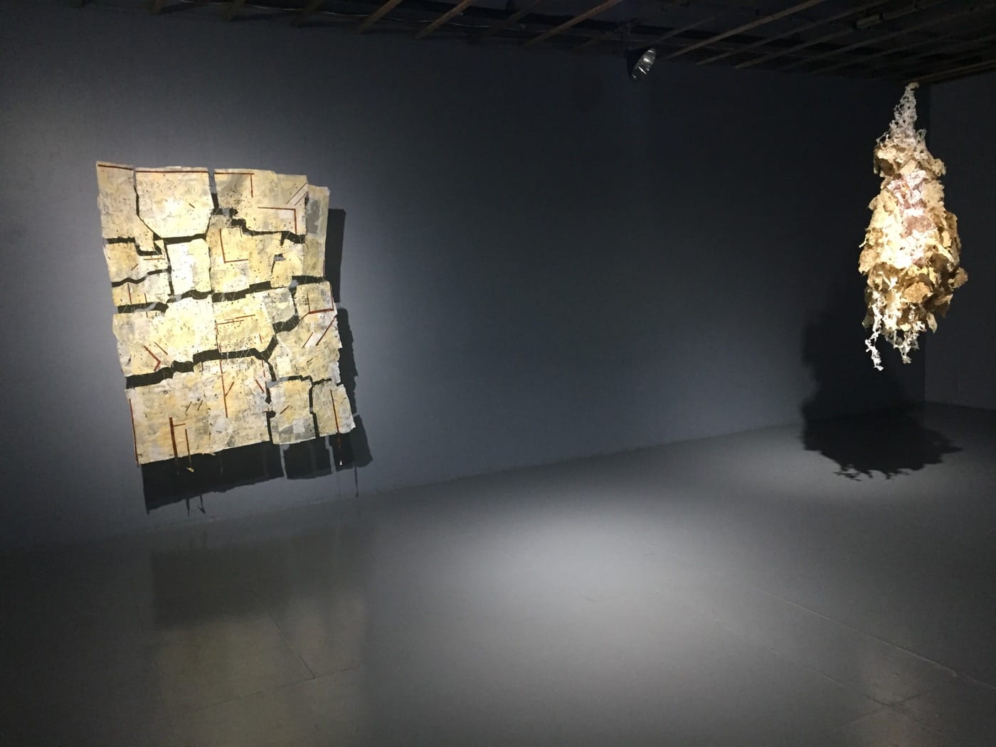 Installation View of Roya Amigh's <em>In my sleep I migrate back </em> with "Back and Forth" (2017, left) thread, pieces of cloth and paper, 49 x 62 in; and "The world is that kind of sleep" (2017, right) dandelions and pieces of cloth, 25 x 25 x 62 in (all photos by the author for Hyperallergic)
