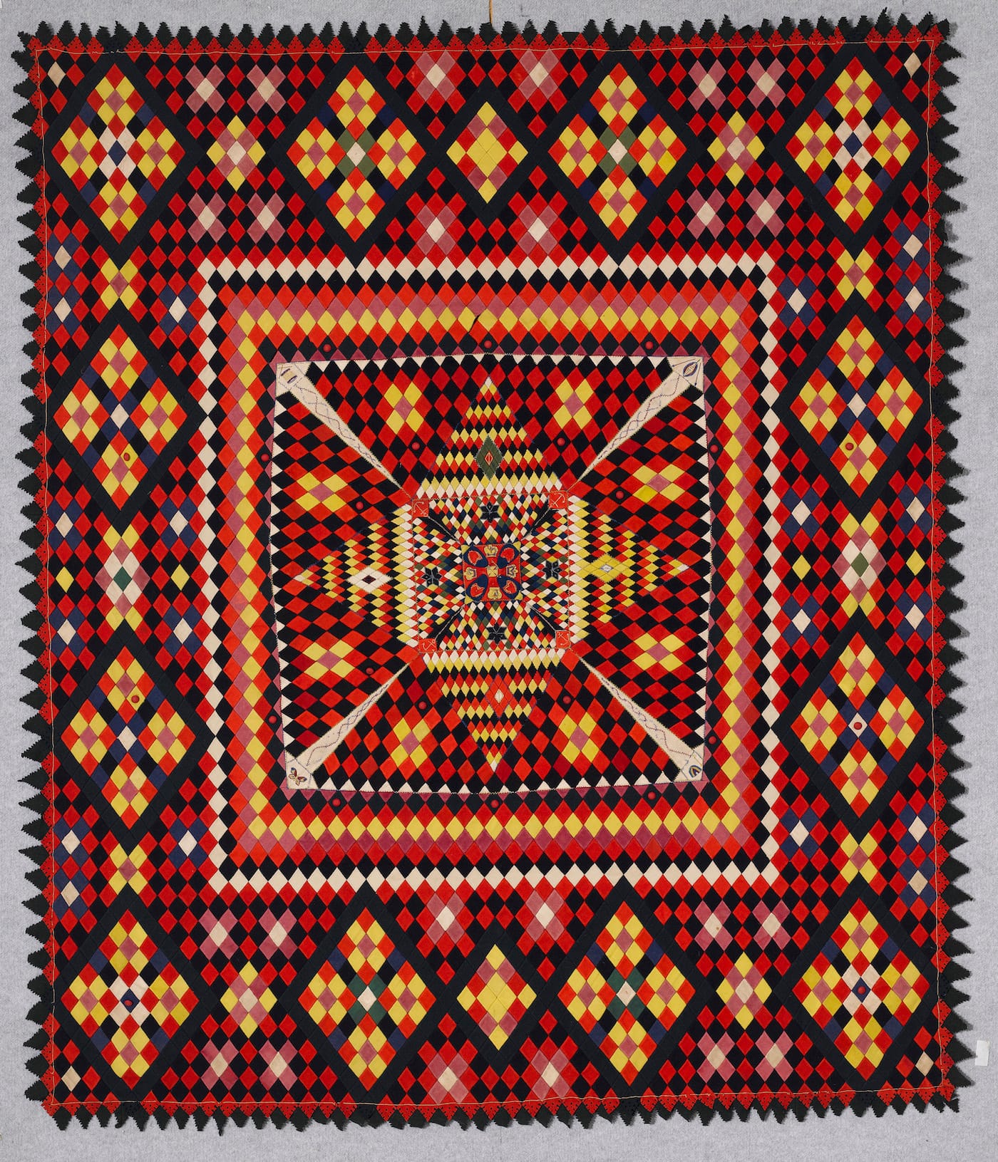Artist unidentified, Anglo-Zulu War Army Quilt (South Africa or United Kingdom, late 19th century), wool from military uniforms, with embroidery thread; hand-embroidered, with pointed and pinked edges, 86 5/8 x 74 7/8 inches (courtesy the Annette Gero Collection, photo by Tim Connolly, Shoot Studios)