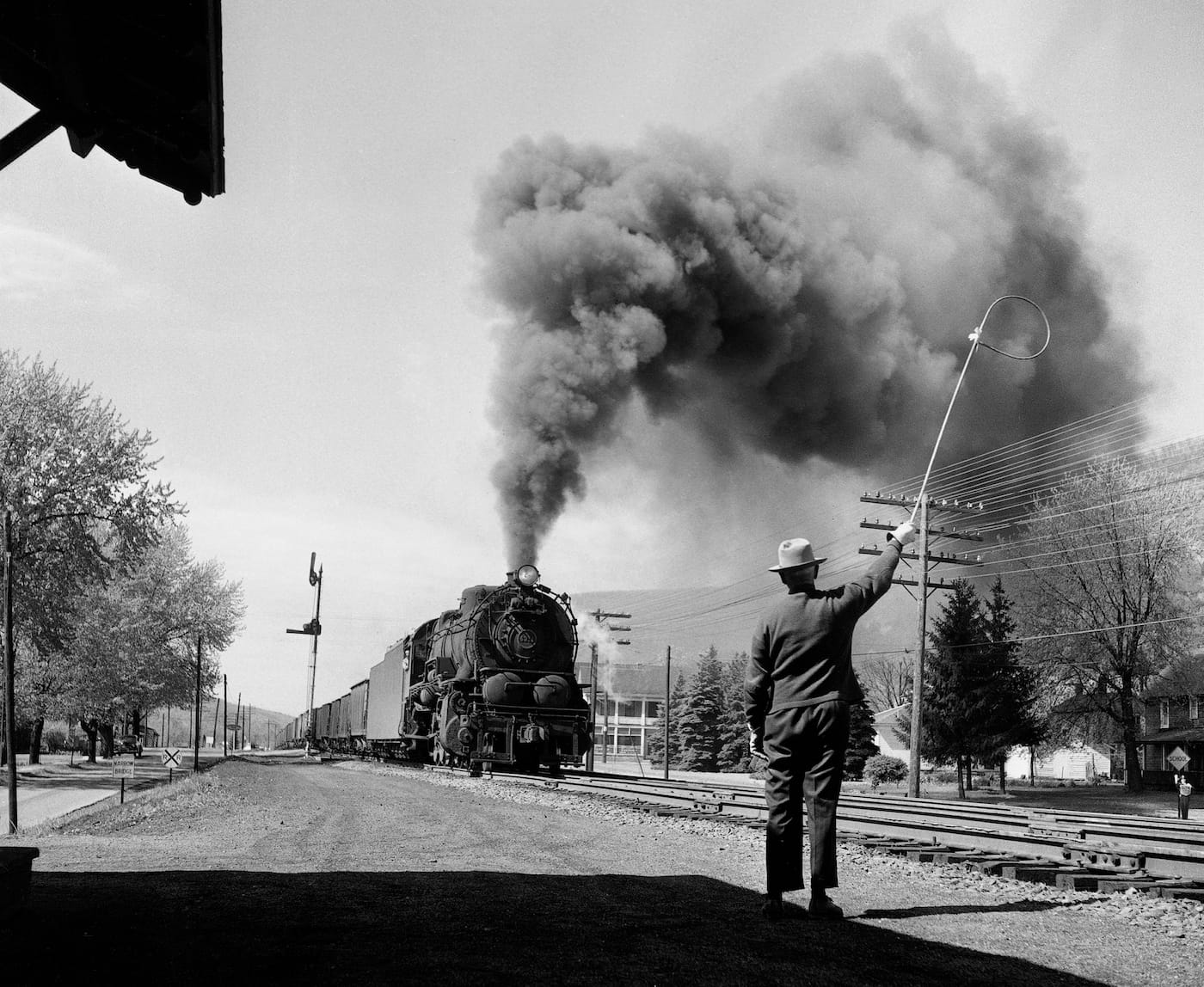 Jim Shaughnessy, "Pennsylvania Railroad operator hoops up train orders to crew of a northbound coal train, Trout Run, Pennsylvania" (1956) (courtesy the artist and Thames & Hudson)