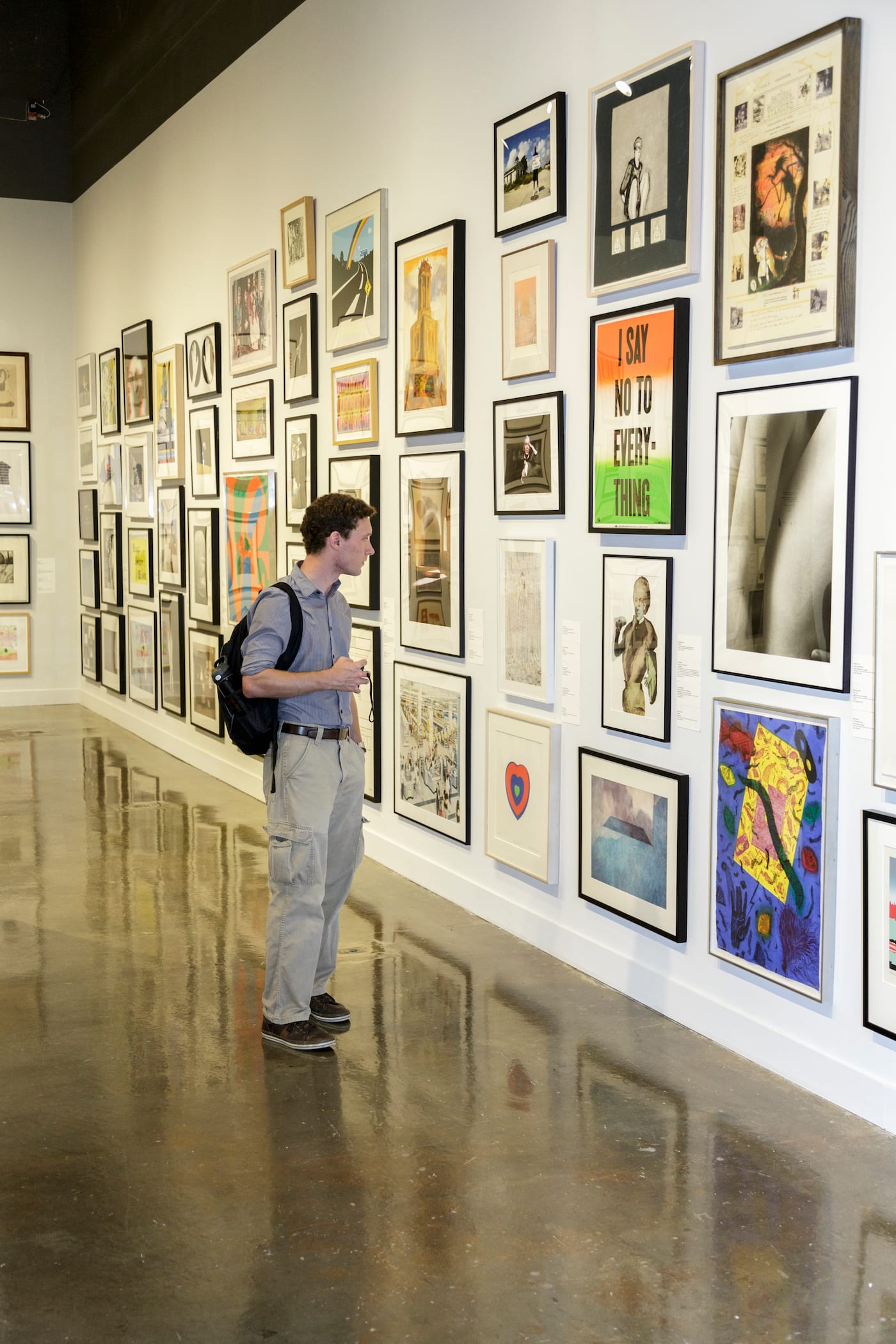An MIT student perusing works available through the school's Student Loan Art Program (courtesy MIT List Visual Arts Center, photo by John Kennard)