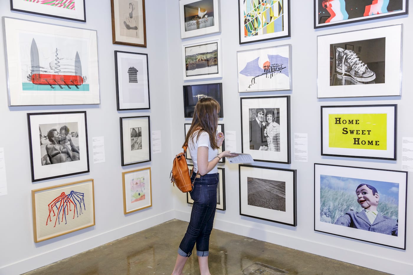 An MIT student perusing works available through the school's Student Loan Art Program (courtesy MIT List Visual Arts Center, photo by John Kennard)