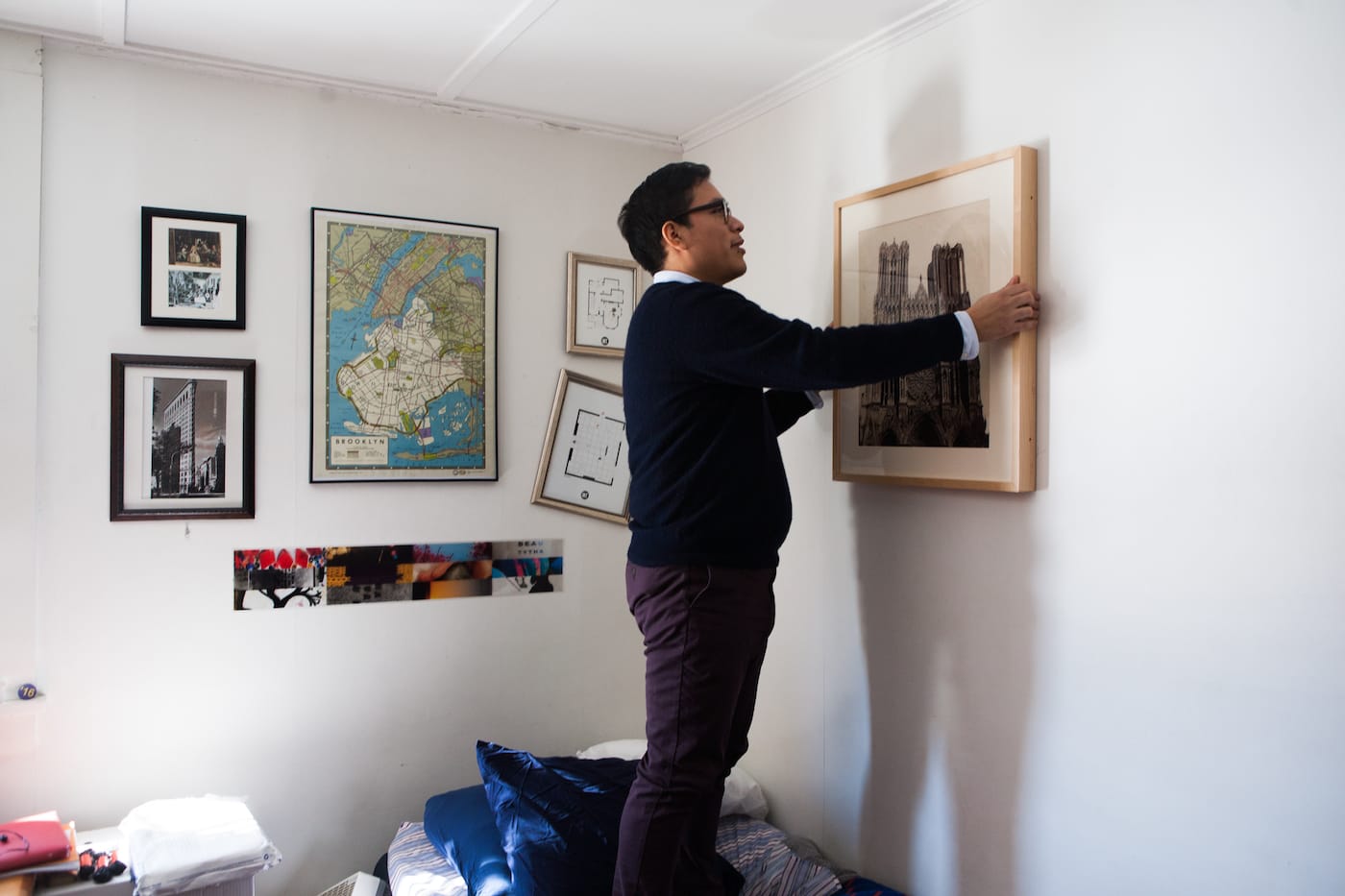 A Williams College student hanging a work on loan from the WALLS program in his dorm room (photo by Julia Sabot, courtesy Williams College Museum of Art)