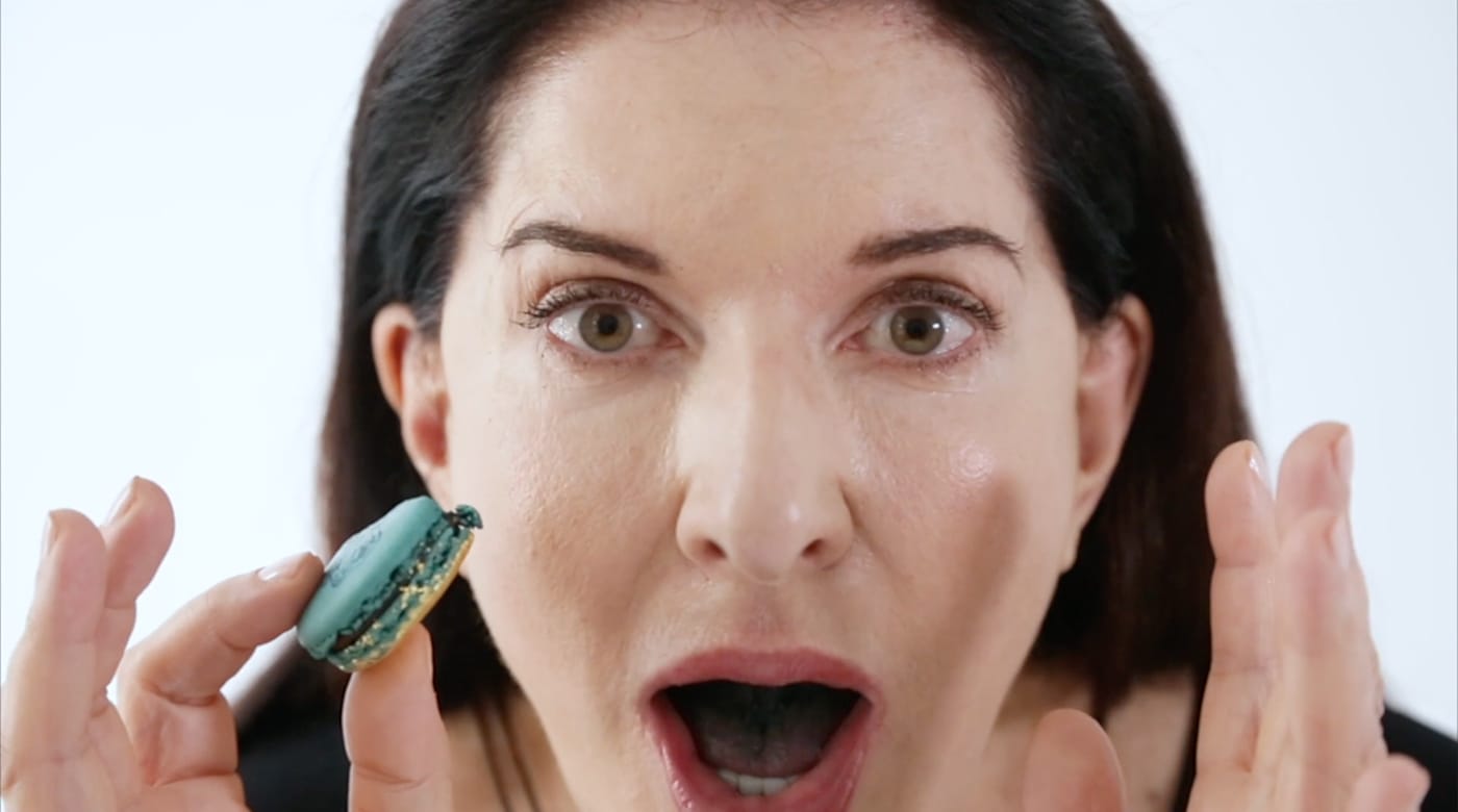 Marina Abramović tastes one of her macarons. (screenshot by the author via Vimeo)