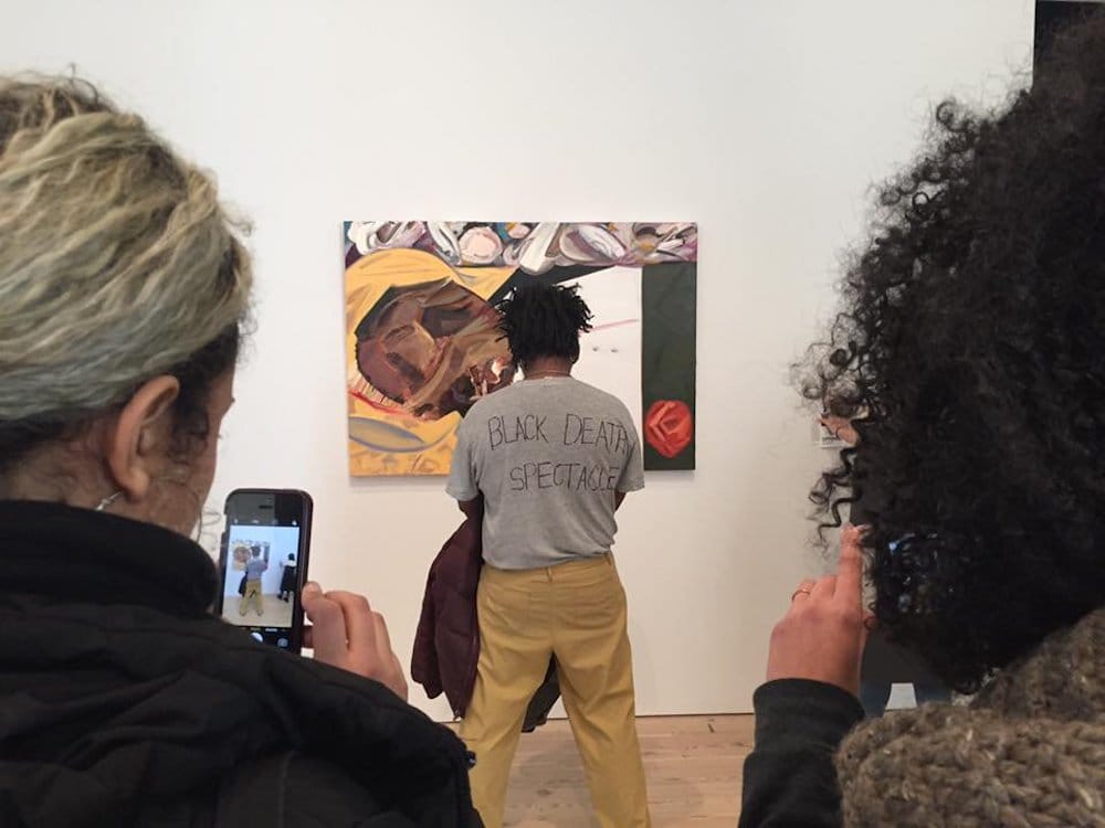 Artist and protester Parker Bright standing in front of Dana Schutz's "Open Casket" (courtesy Parker Bright)