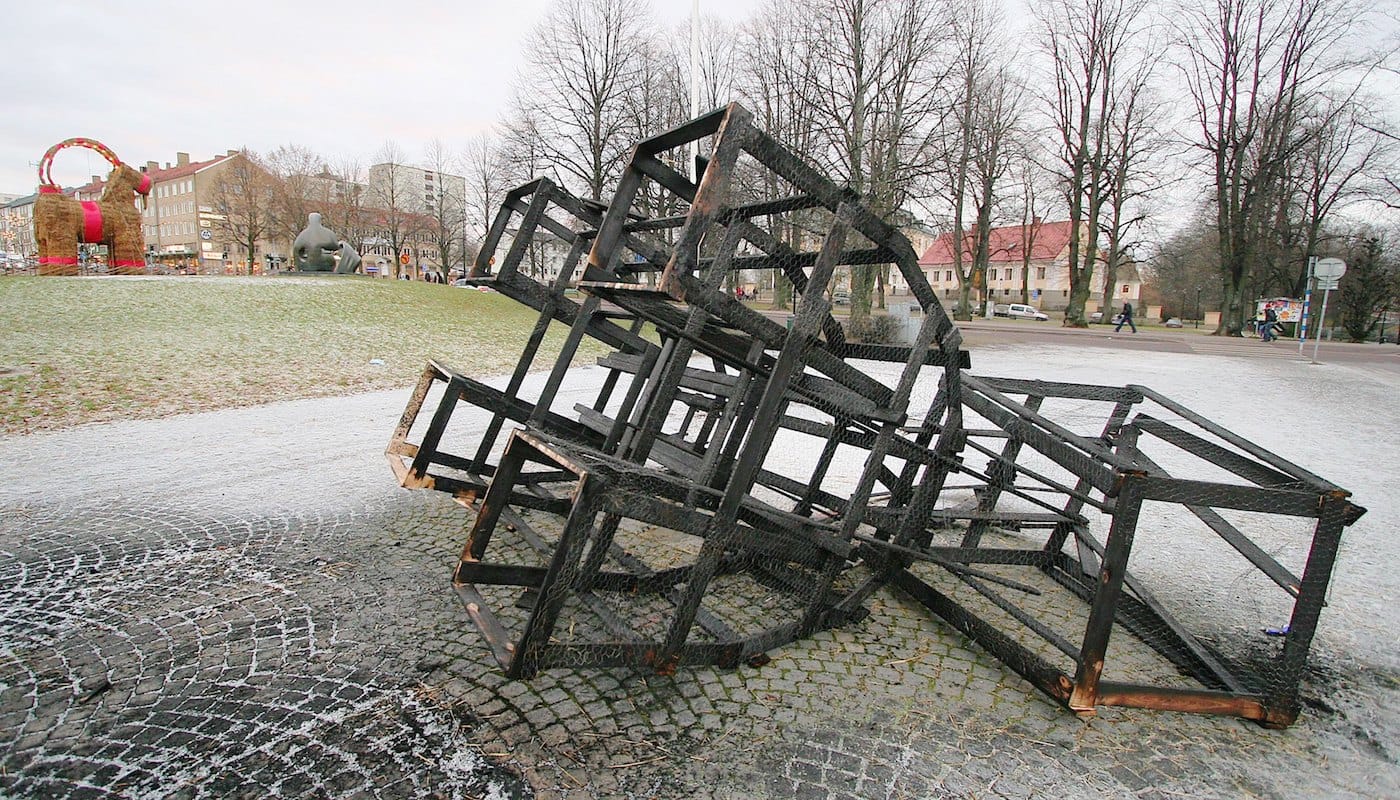 Charred remains of the Natural Science Club's Yule Goat, with the larger Gävle goat in the background (2006) (photo by Stefan/Wikimedia)
