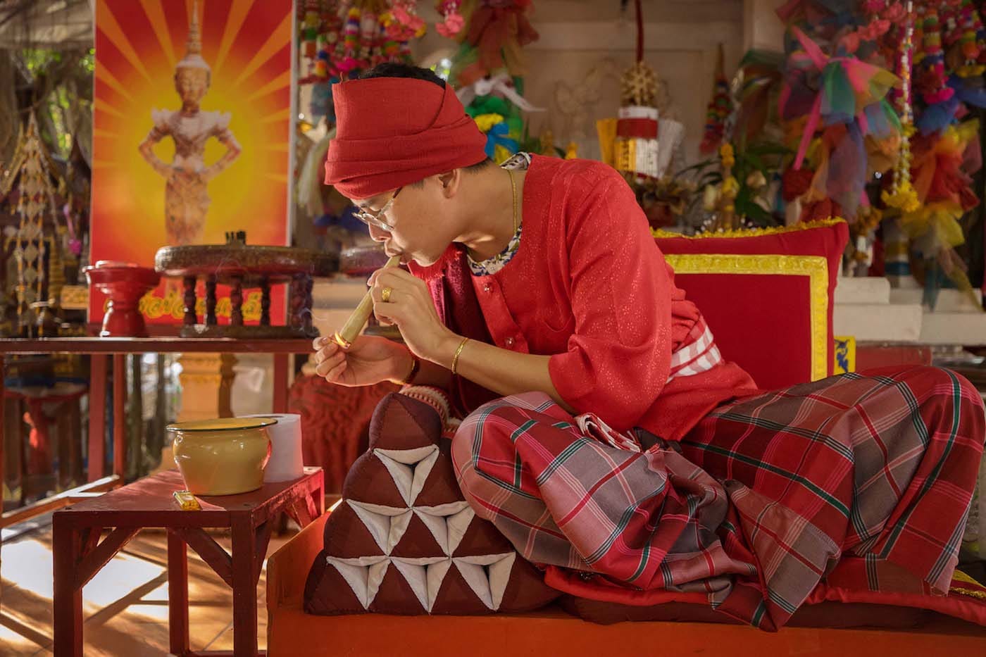 "A maa khii in Chiang Mai lights a traditional cigar for the enjoyment of their spirit." (© Mariette Pathy Allen, from <em>Transcendents: Spirit Mediums in Burma and Thailand</em>, courtesy Daylight Books)