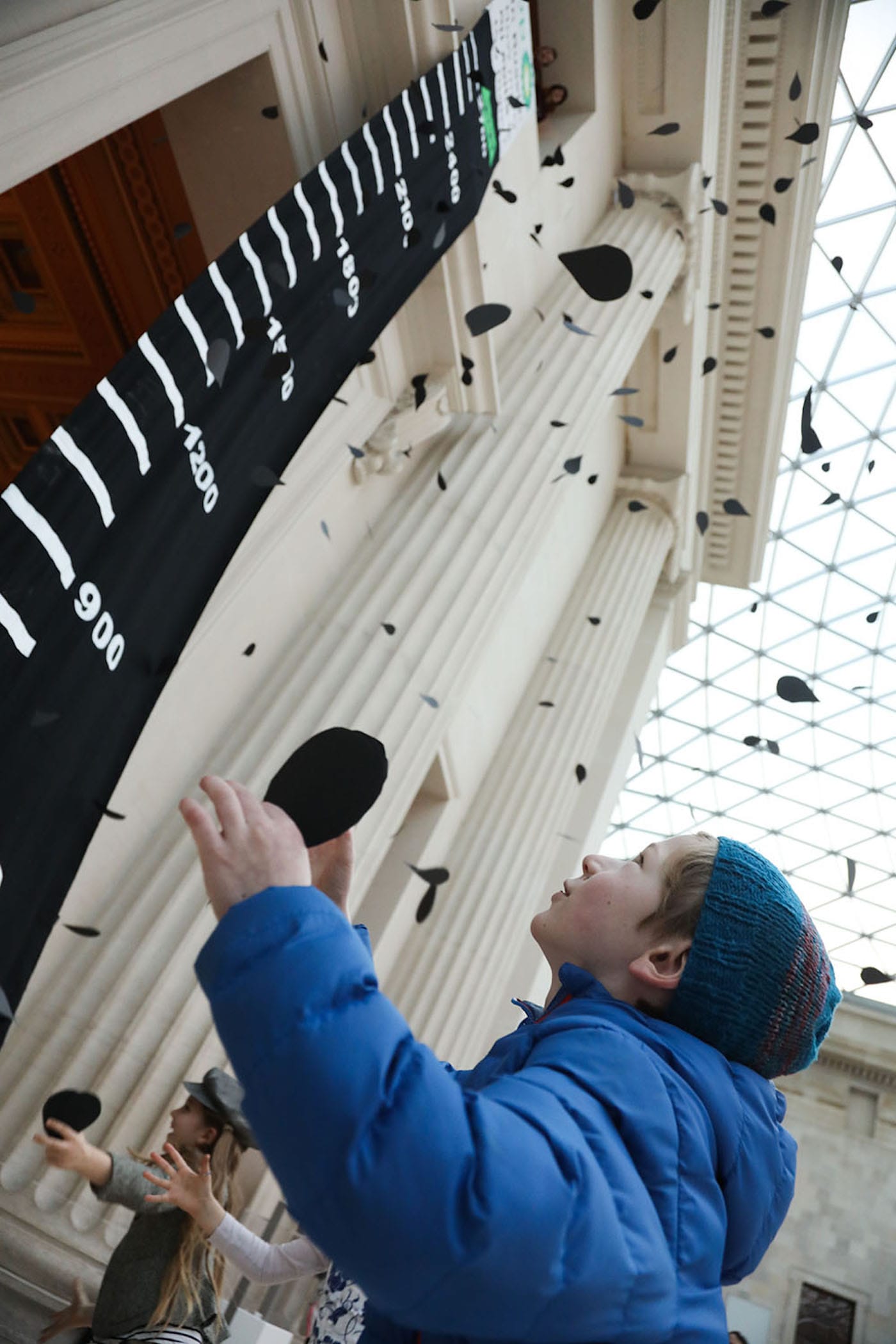 Activist theater group BP Or Not BP? drop thousands of paper oil drops in the British Museum in protest of BP's sponsorship of the museum. (photo by Kristian Buus, courtesy BP Or Not BP?)