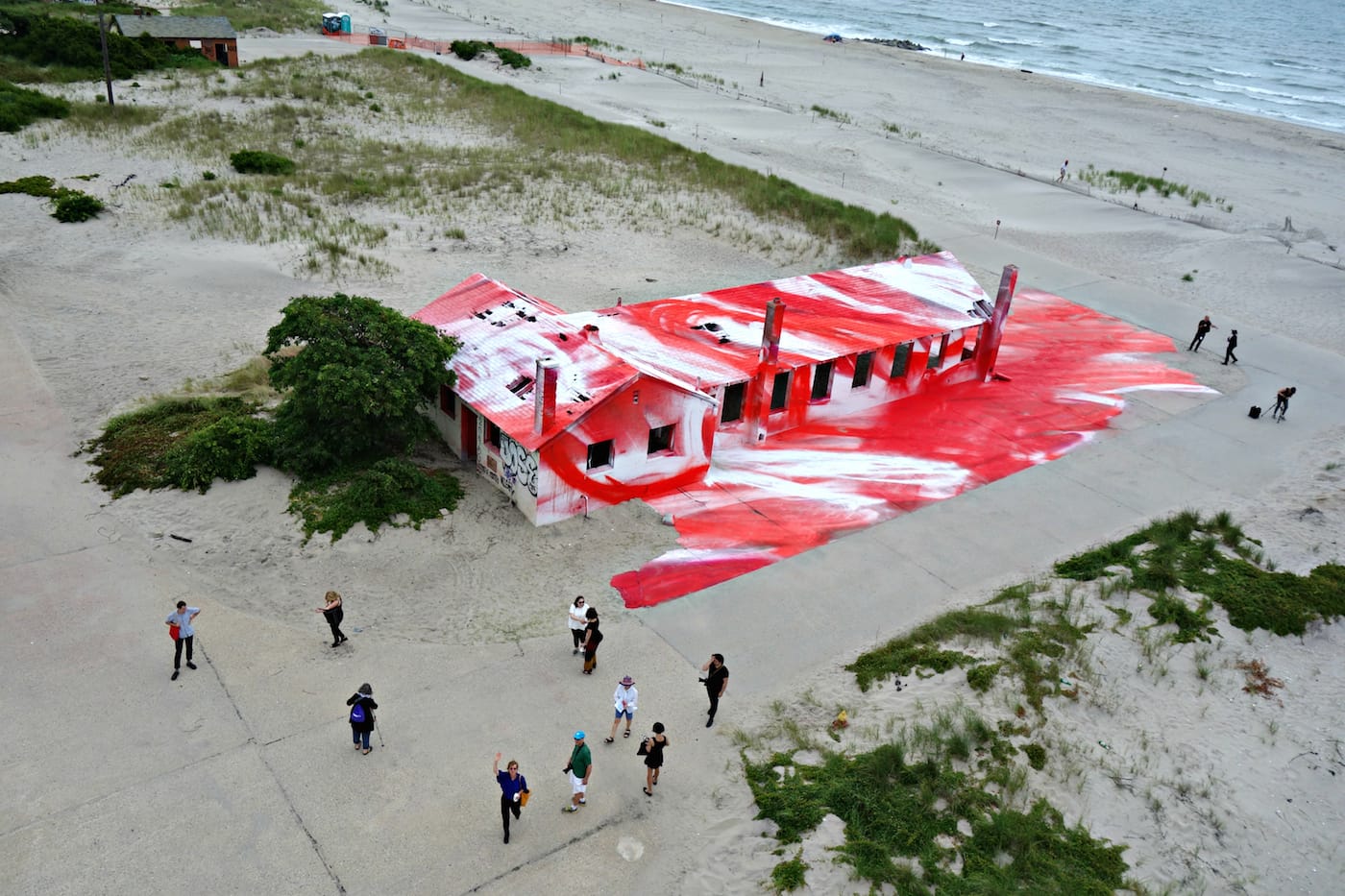 Aerial view of Katharina Grosse’s “Rockaway!” at Fort Tilden, with the artist waving below (photo by Allison Meier/Hyperallergic)