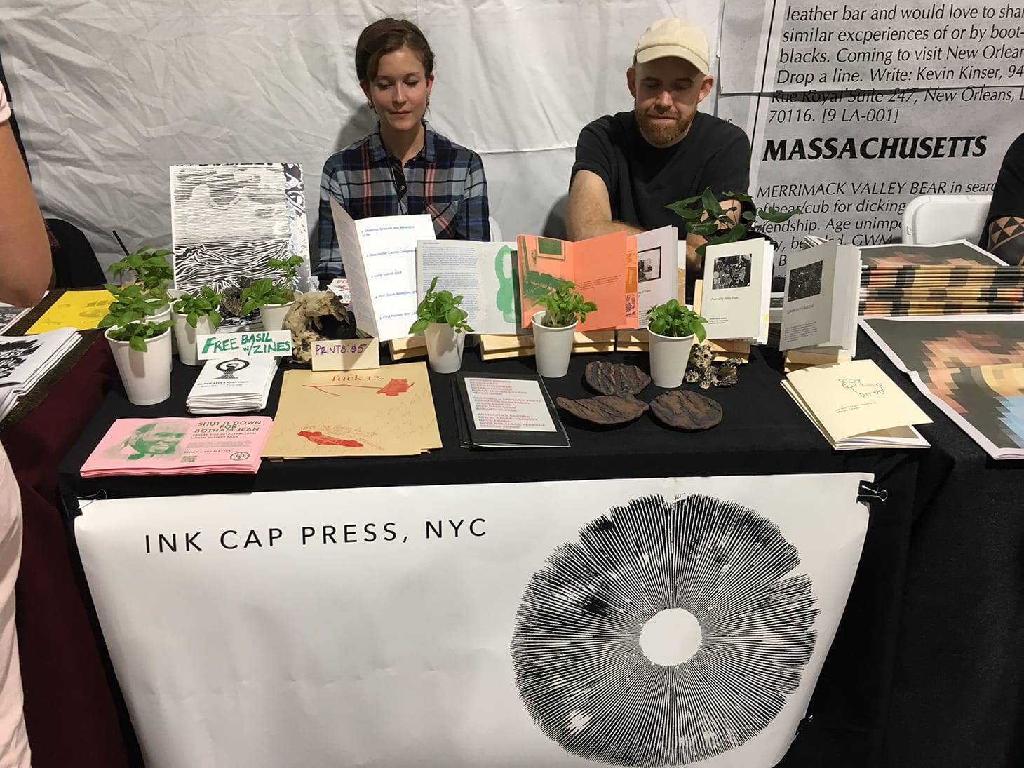Babbie Donnington (left) and Thompson Harris (right) with free basil at the table for Ink Cap Press