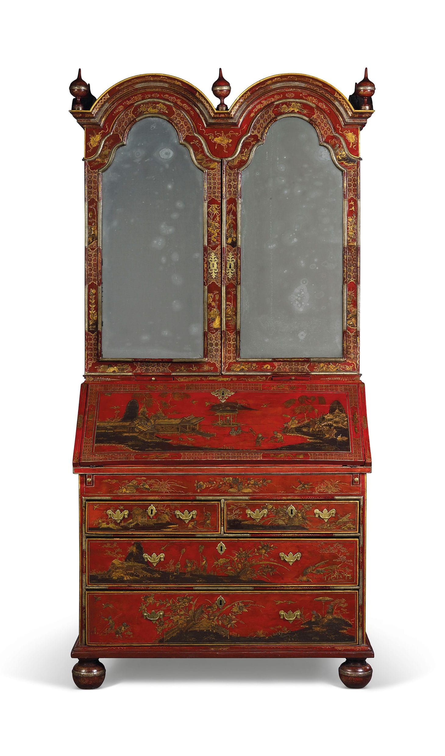 A George II red, silver, and gilt-Japanned bureau cabinet (c. 1730), double-domed top with turned finials above a pair of mirrored doors enclosing an adjustable shelf, pigeon holes and six small drawers and with a pair of candle slides, the fall front revealing a fitted interior with further pigeon holes, open shelves and five drawers above a red leather-lined writing-surface and a well, with two short and two long drawers below, on turned feet, restorations and replacements, 86 ½ inches high, 43 ½ inches wide, 23 inches deep (image courtesy Christie's)