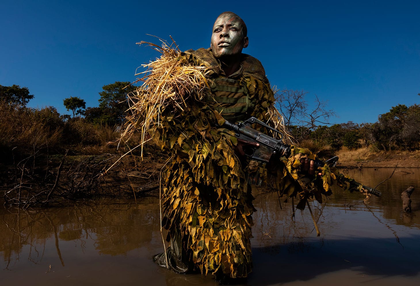 Brent Stirton, "Akashinga - the Brave Ones" (2018): Petronella Chigumbura (30), a member of an all-female anti-poaching unit called Akashinga, participates in stealth and concealment training in the Phundundu Wildlife Park, Zimbabwe (© Brent Stirton, Getty Images)