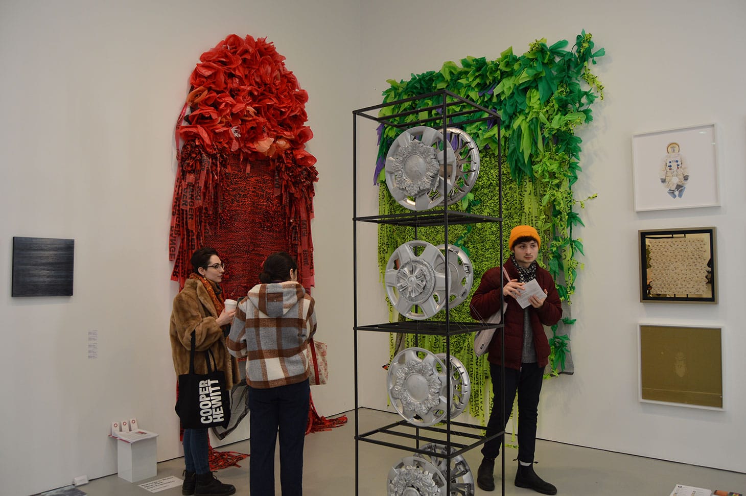 Borinquen Gallo, installation shot; left: "Deadly Poppy Field" (2016), caution tape, plastic bags, debris netting, ink; right: "Green Unplugged" (2016), caution tape, plastic bags, debris netting, URL cables; center: "Heaven Wheels Above You" (2018–19), cast architectural details, found auto rims, Bondo, paint; Burning in Water gallery