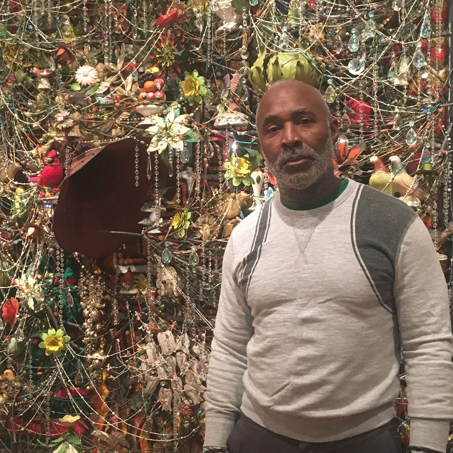 Nick Cave and “Wall Relief” (2013), mixed media, including ceramic birds, metal flowers, afghans, strung crystals, and gramophone (photo by the author for Hyperallergic)