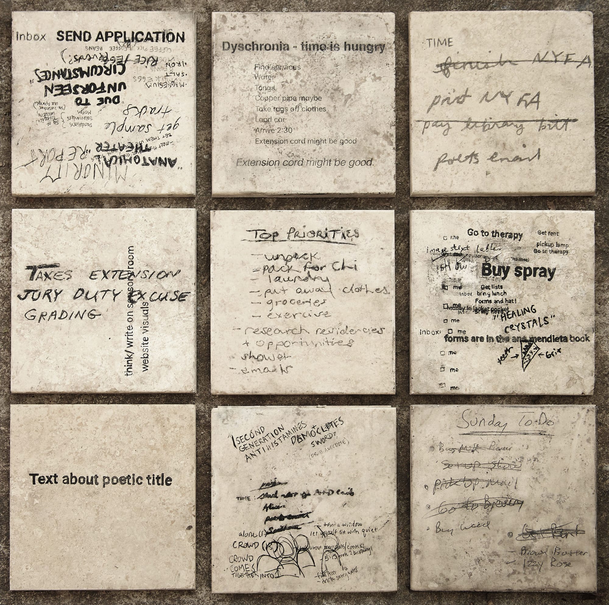 Nine beige marble tiles are arranged in a loose square grid against dark cement. Each tile displays a cacophony of black text. Handwritten notes and typeface reminders interchange and overlap, as does the orientation, size and legibility of each note. One square features only one line of text (typeface). It reads: "Text about poetic title.” To its left and right, hand scrawled notes overlap. A few moments of notable legibility across the piece; Get Rent, Due to unforeseen circumstances, Anatomical Theater, Taxes Extension/Jury Duty Excuse, Finish NYFA, Dyschronia: Time is hungry, Top Priorities, Buy Spray.