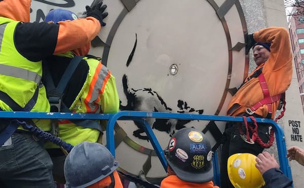 Workers taking down the Banksy at 14th Street and Sixth Avenue in Manhattan (photo by Melissa Stern for Hyperallergic)